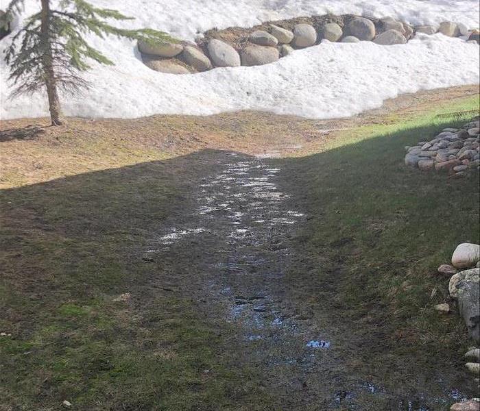Snow on the ground creating water on the grass.