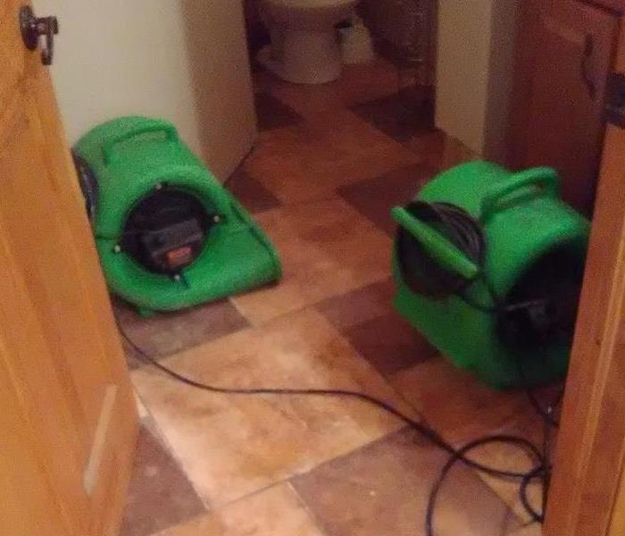 Bathroom with green air movers on the floor. 