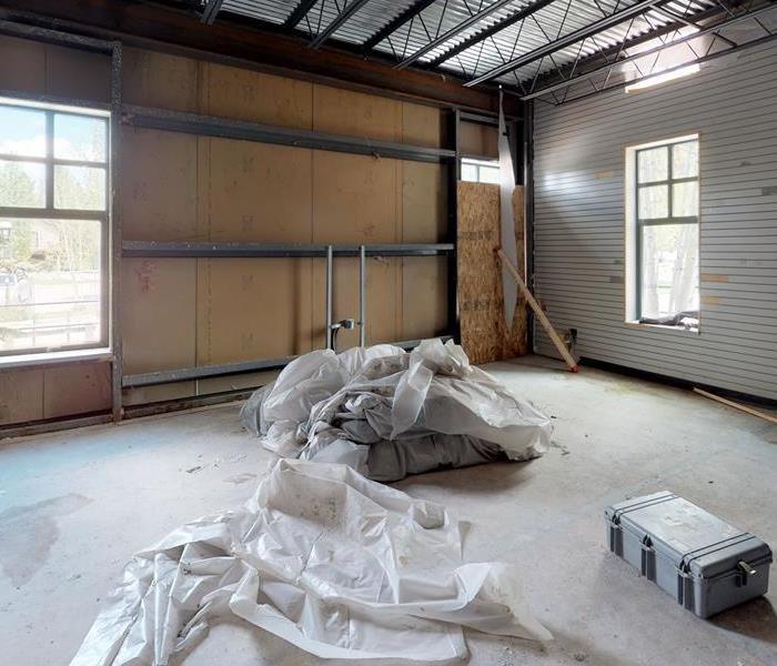 White protective sheets on the floor and walls of this garage. 