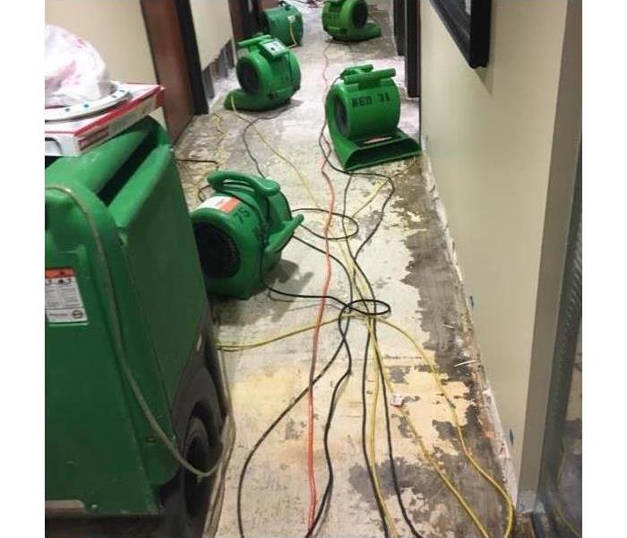 Six green air movers on a concrete flood. 