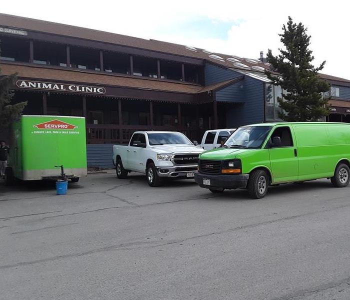Green SERVPRO van parked outside a building. 