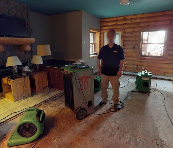 Room filled with green air movers, and raw exposed wood on the walls and floor. 